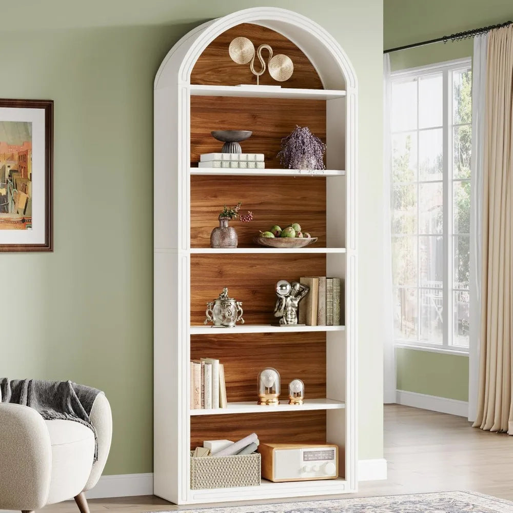 White bookshelf with wooden shelves in a room with a green wall and a window.